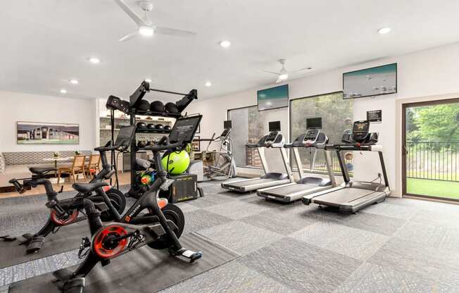 a gym with exercise bikes and a wall with graffiti