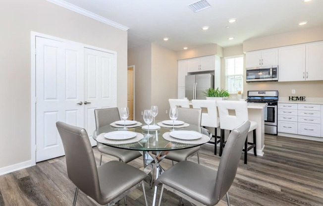 a dining room with a glass table and chairs