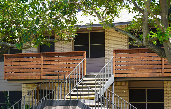 a building with stairs and a tree in front of it