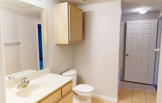 A bathroom with a toilet, sink, and medicine cabinet.