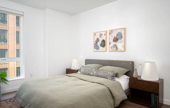 a bedroom with a large bed and two paintings on the wall at Slabtown Square Apartments, Portland