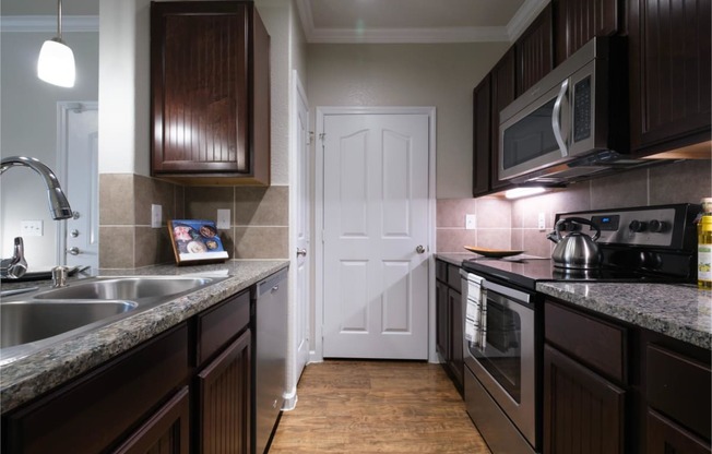 kitchen with custom cabinetry and stainless appliances at Park at Magnolia apartments