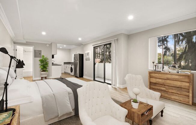 A modern bedroom with a large bed, a white chair, and a wooden cabinet.