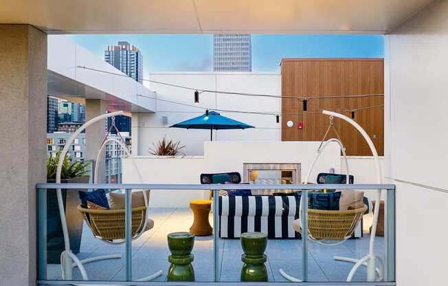 a balcony with a table and chairs and a fireplace with a blue sky in the background