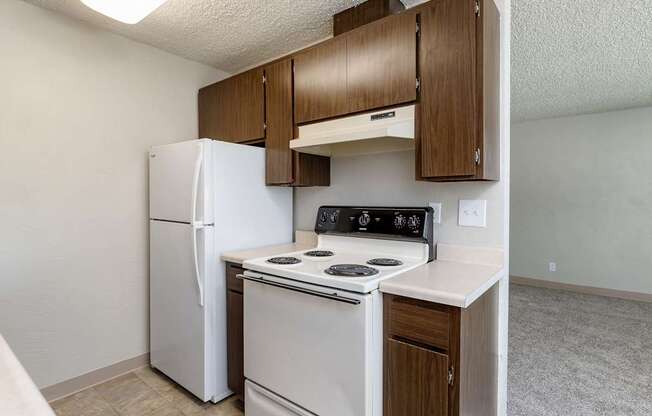 A kitchen with a white stove and refrigerator.