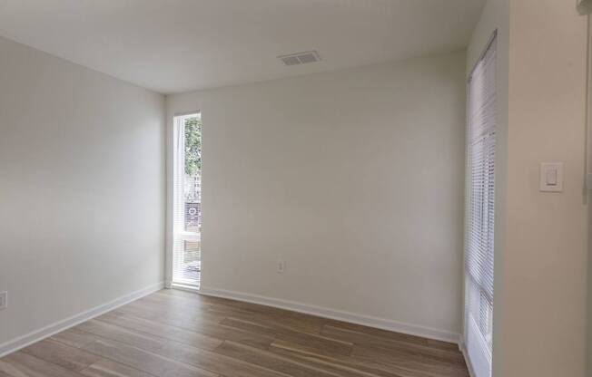 A room with wooden flooring and a window.