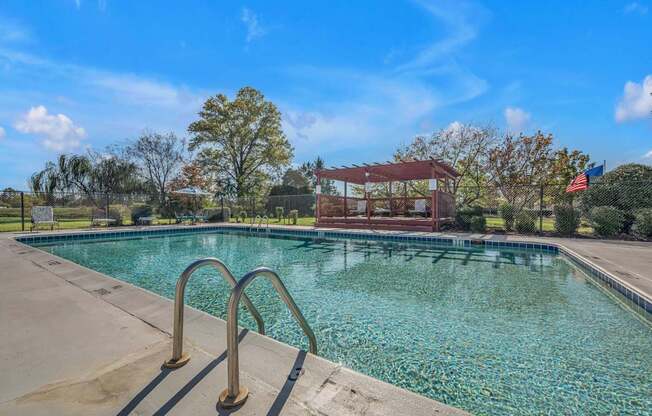 A swimming pool with a diving board and a building in the background.