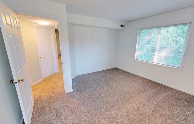 a bedroom with a large window and a white door