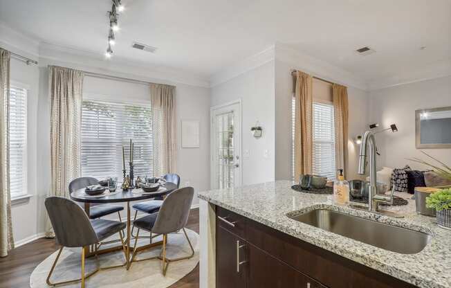 a kitchen with a sink and a table with chairs