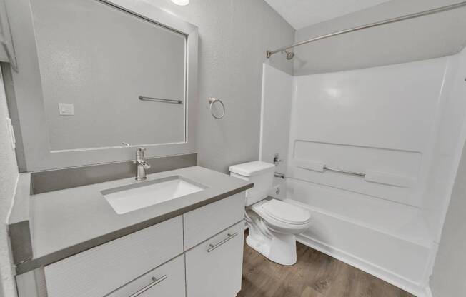 A white bathroom with a sink, toilet, and bathtub.