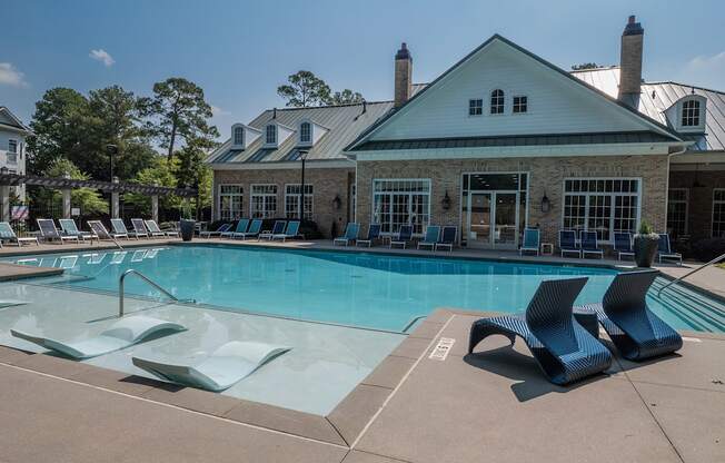 A pool with a slide and a building behind it.