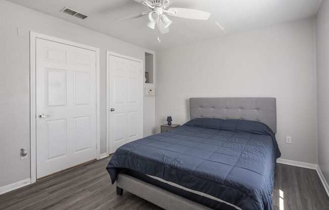 a bedroom with a bed and a ceiling fan