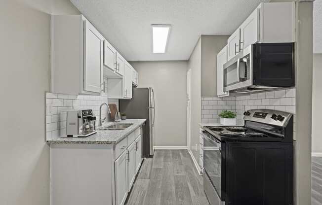 a kitchen with white cabinetry and black appliances