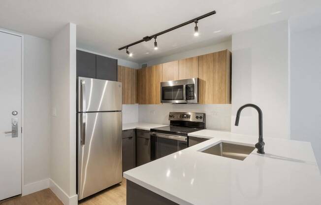 a modern kitchen with stainless steel appliances and white counter tops