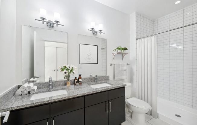 a bathroom with two sinks and a shower and a toilet