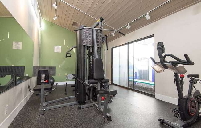 A gym with a treadmill, elliptical trainer and a stationary bike.