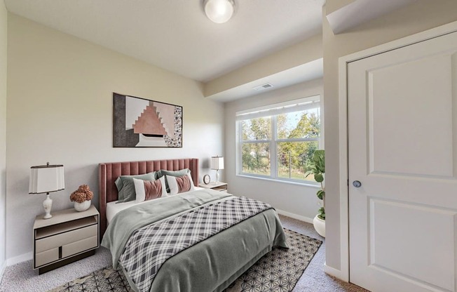 A bedroom with a bed, nightstand, and window.