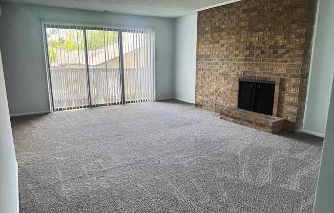 A room with a fireplace and a sliding glass door.