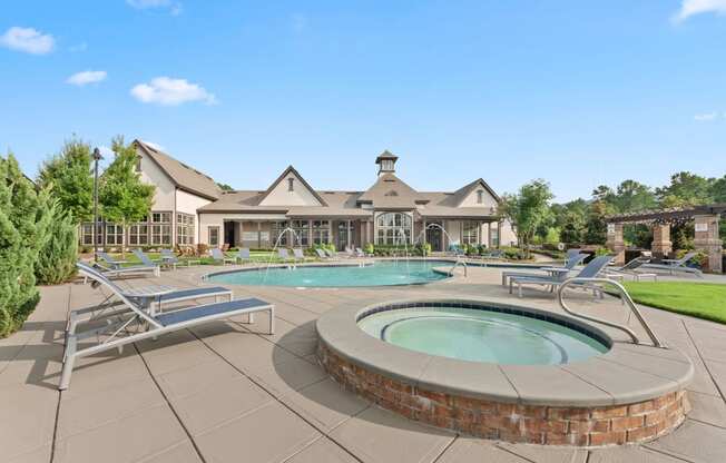 a pool with chairs and a spa in front of a house