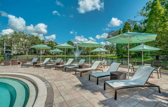 Front pool area with lounge seating and umbrellas