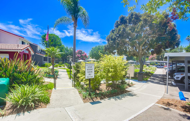 a sidewalk in front of a house with a sign on the sidewalk