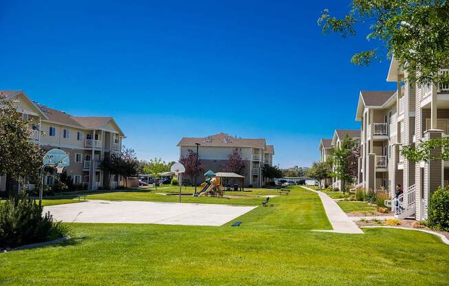 A sunny day at a residential complex with a playground in the middle.