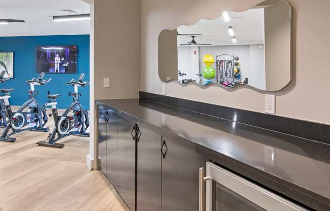 a fitness center with exercise bikes and a mirror on the wall