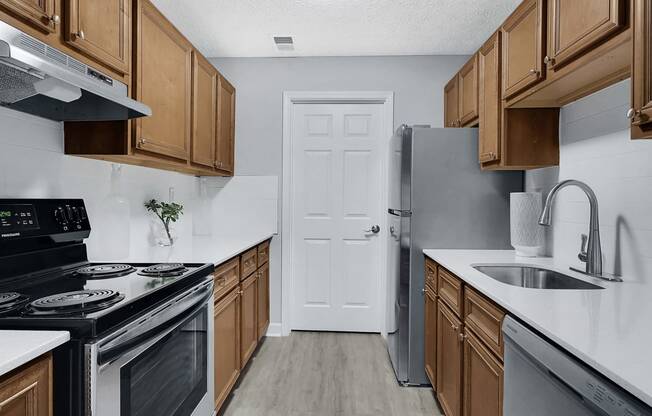 a kitchen with wooden cabinets and stainless steel appliances at Stonewater Apartments, Louisville, 40241