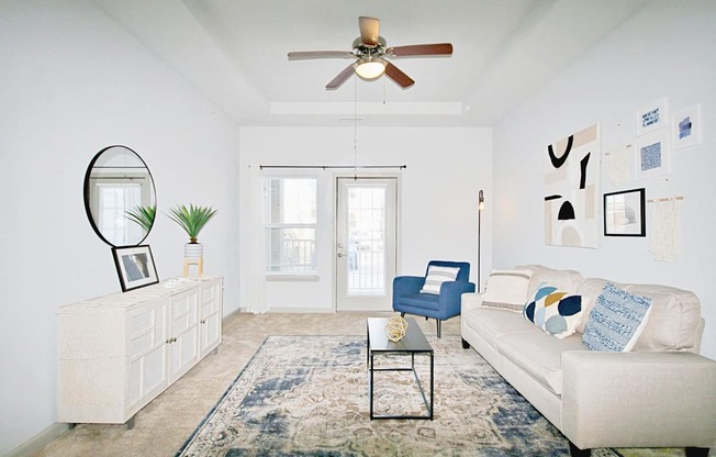 a living room with a white couch and a ceiling fan