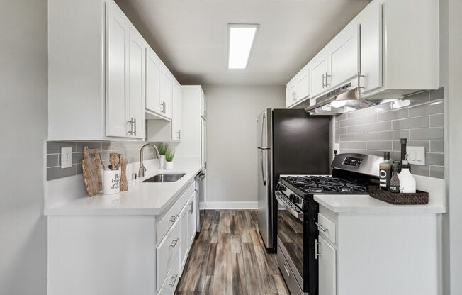 Model Kitchen with Wood-Style Flooring & White Cabinets at Forest Park Apartments in El Cajon, CA.