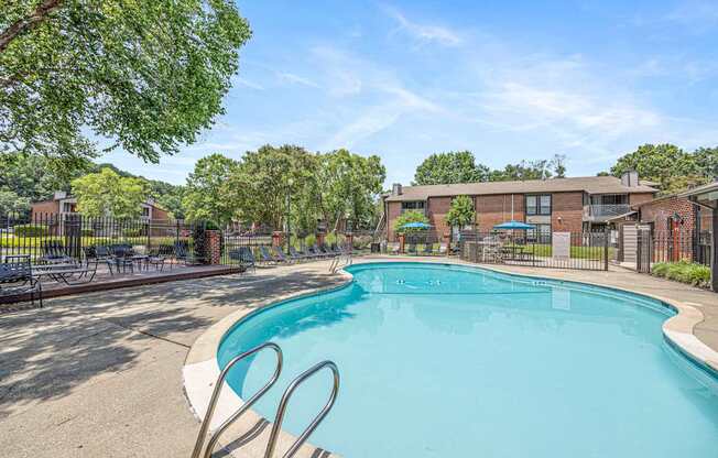 A large swimming pool surrounded by trees and a fence.