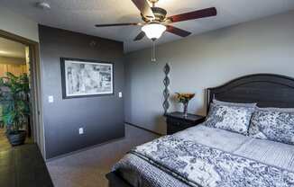 the master bedroom has a large bed and a ceiling fan