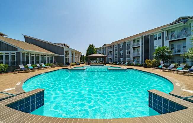 a large swimming pool in front of an apartment building