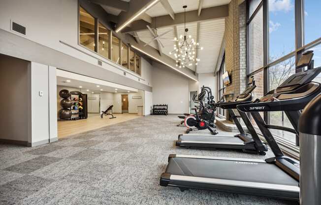 a gym with treadmills and other exercise equipment in the lobby of a building