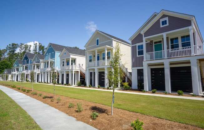 a row of town homes with lawns and trees in front of them