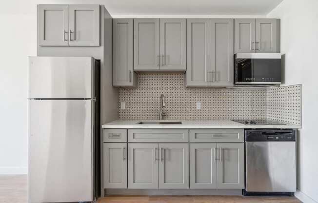 an empty kitchen with white cabinets and a refrigerator