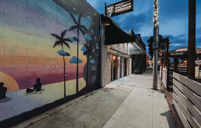 a mural on the side of a building on a sidewalk