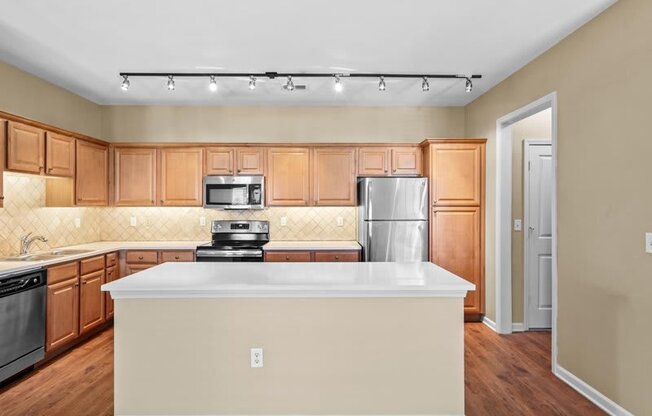 an empty kitchen with a white counter top