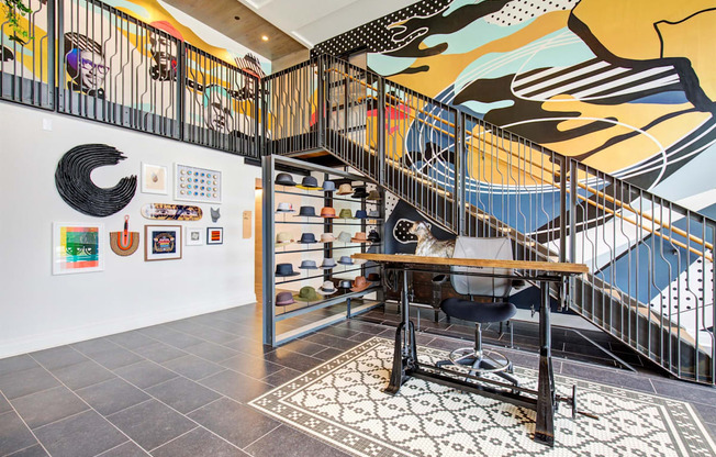 a home office with a desk and a staircase with art on the wall at Coda at Bryant Street, Washington, DC