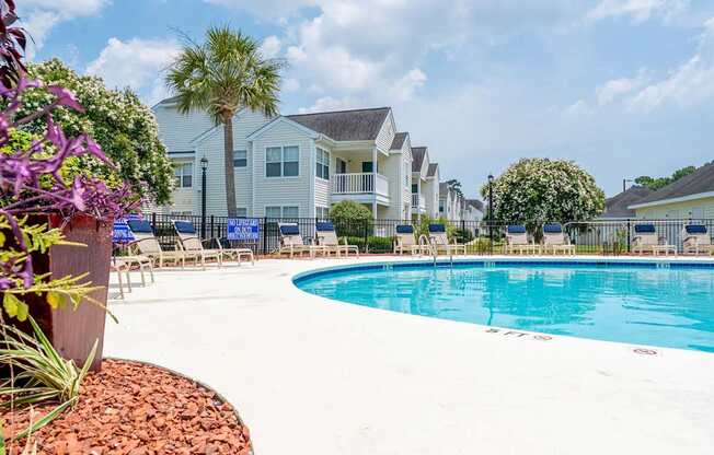 A swimming pool in a residential area with houses in the background.