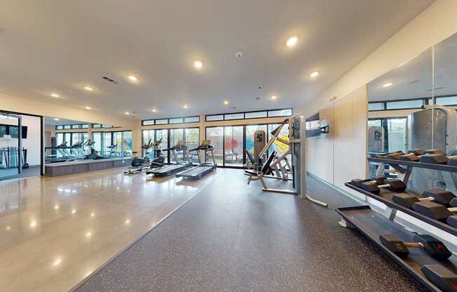A spacious airport baggage claim area with a conveyor belt and a few chairs.