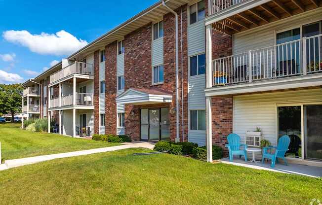 Apartment building with blue chairs on the balcony.