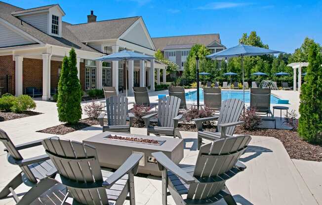 a patio with a table and chairs and a pool in the background