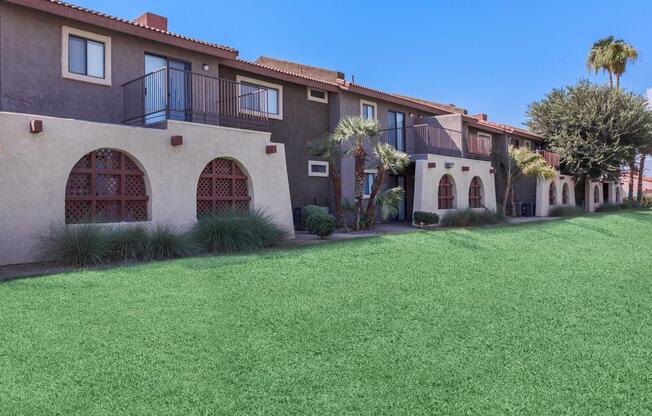 a large brick building with green grass in front of a house