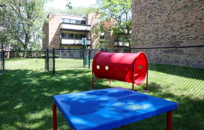 a red mailbox on a blue picnic table in a park