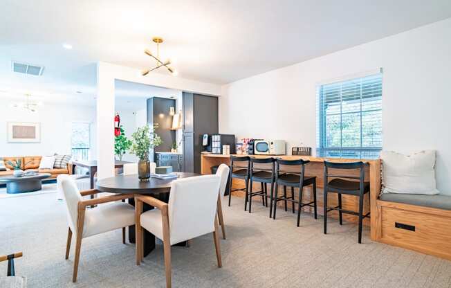 a living room and dining room with a table and chairs and a kitchen