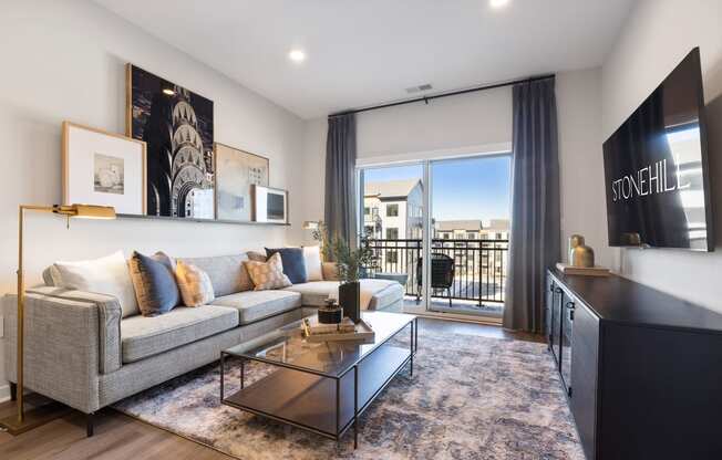 an apartment living room with a couch and a coffee table and a balcony