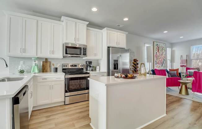 A modern kitchen with white cabinets and stainless steel appliances.