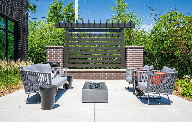 a patio with chairs and a fire pit