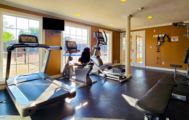 a gym with weights and a tv on the wall